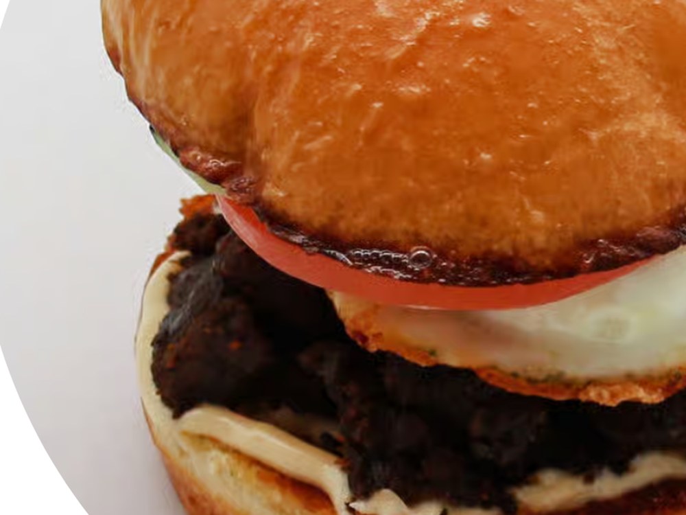 Beef Tapa Sandwich with fried egg and vinegar chili mayo on a bun